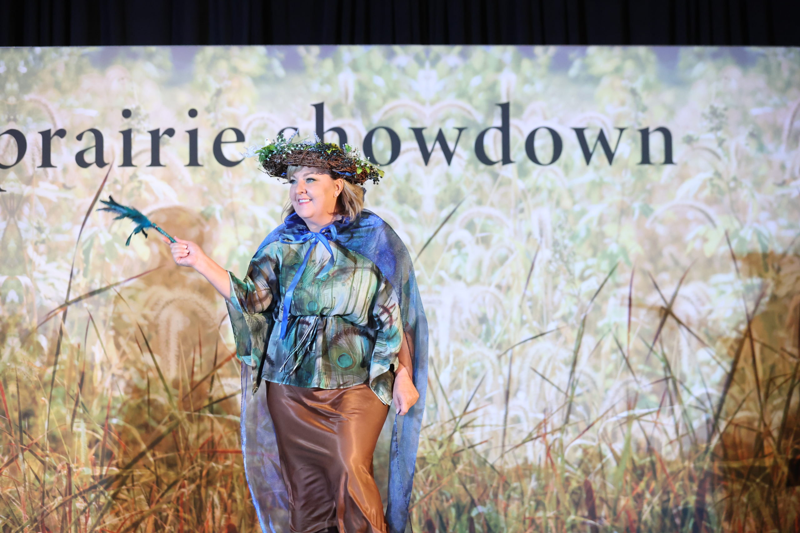 A woman dressed up with peacock feathers and a flowery nest on top of her head like a crown