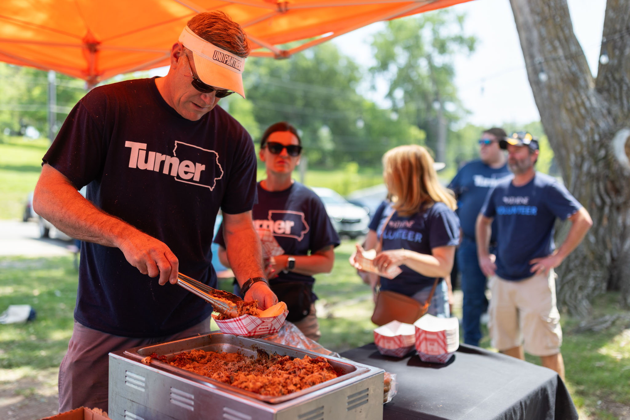 A group of volunteers getting pulled pork sandwiches