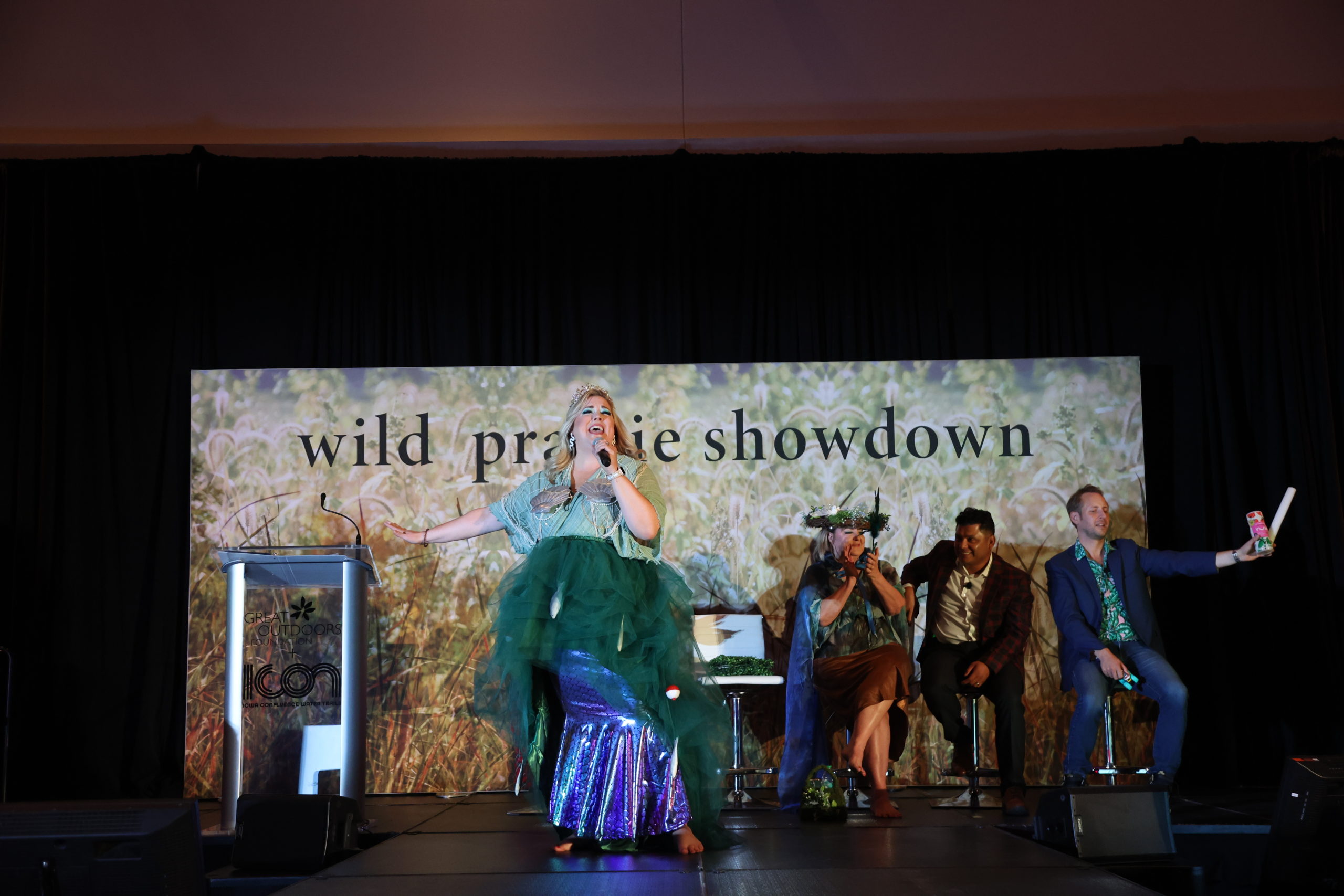 A woman performing on stage while dressed as a mermaid