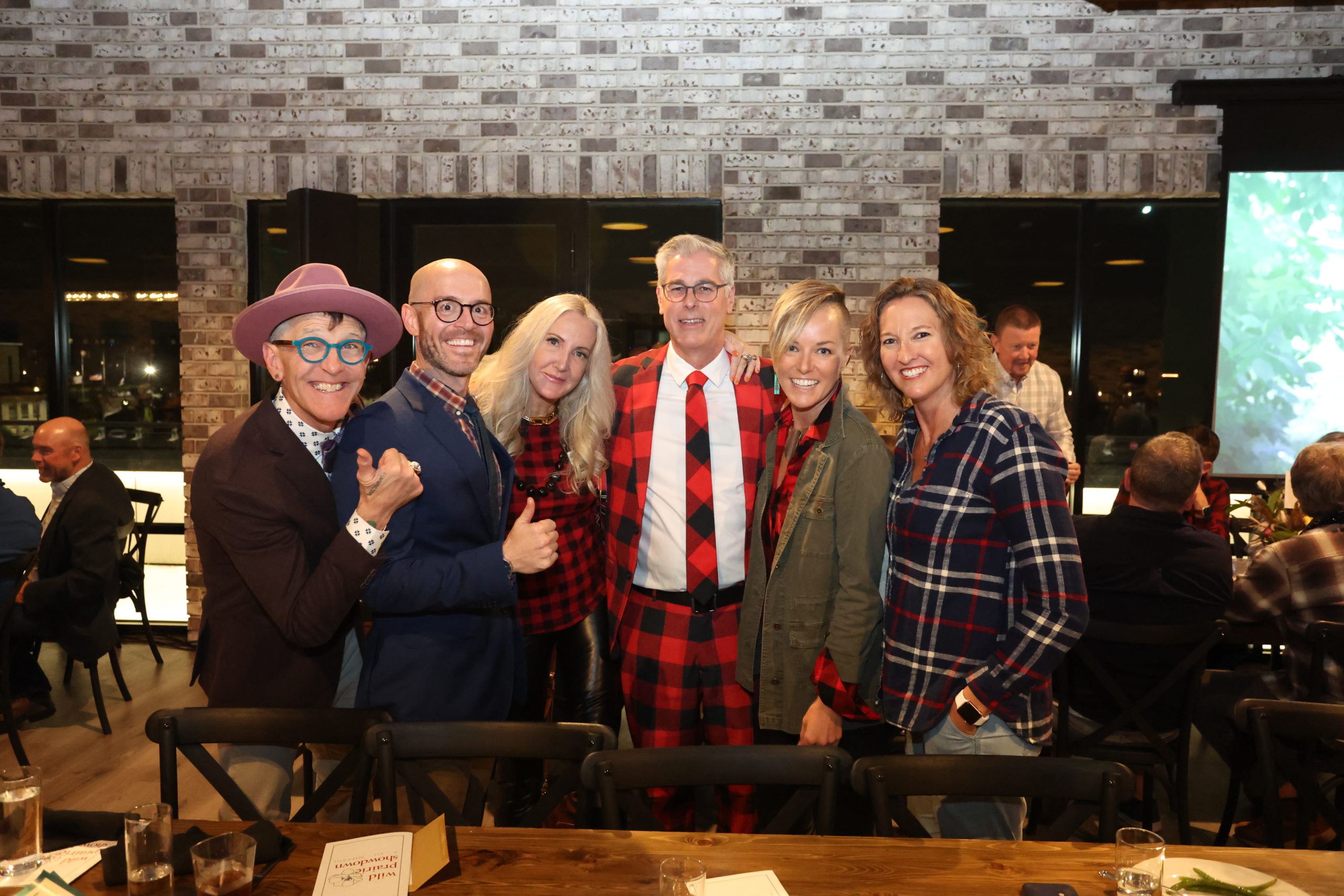 A group of 6 people wearing checkered clothes and plaid