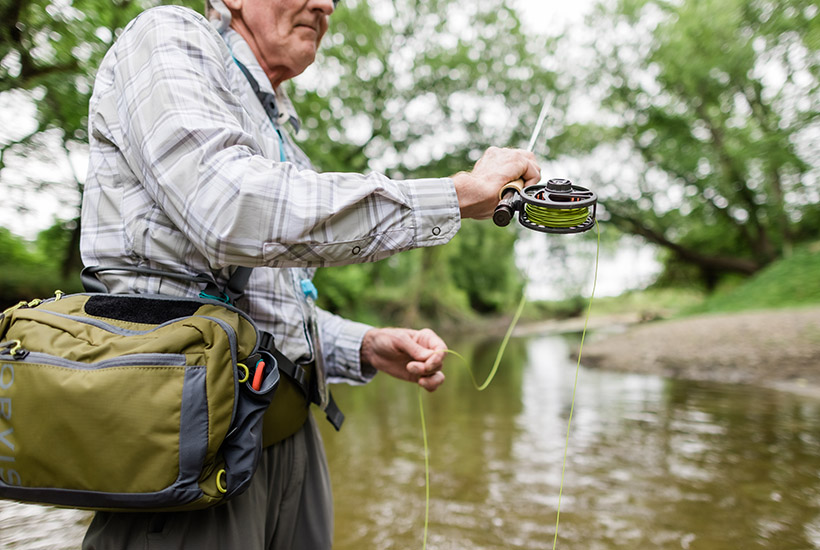A view of a man's green fly line before he casts up the river.