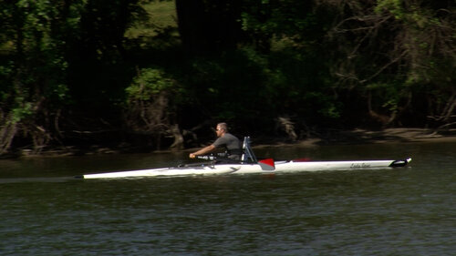 A side view of a man para-rowing on the Des Moines River