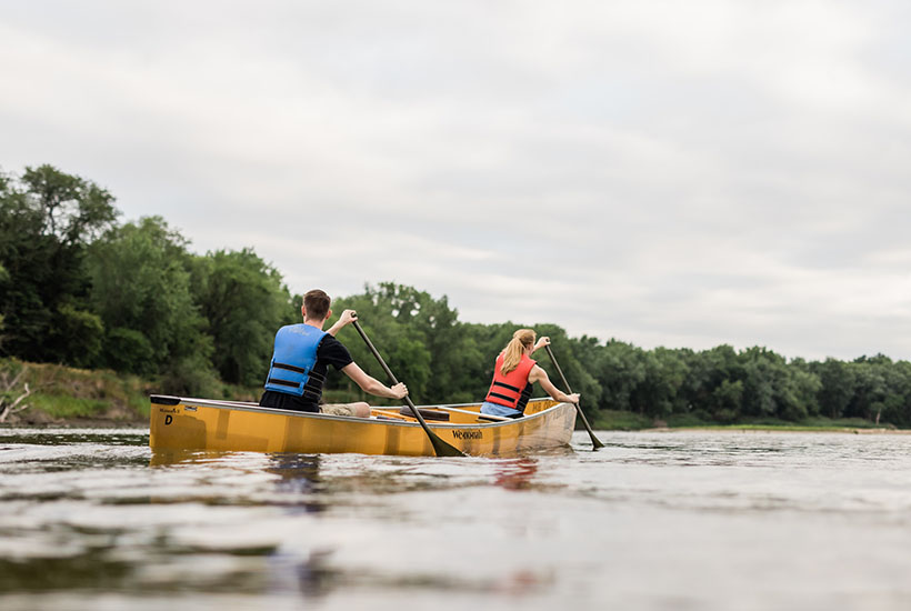 Two people paddling on the right side of their canoe