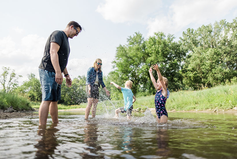 A family of four splashing each other in Fourmile Creek
