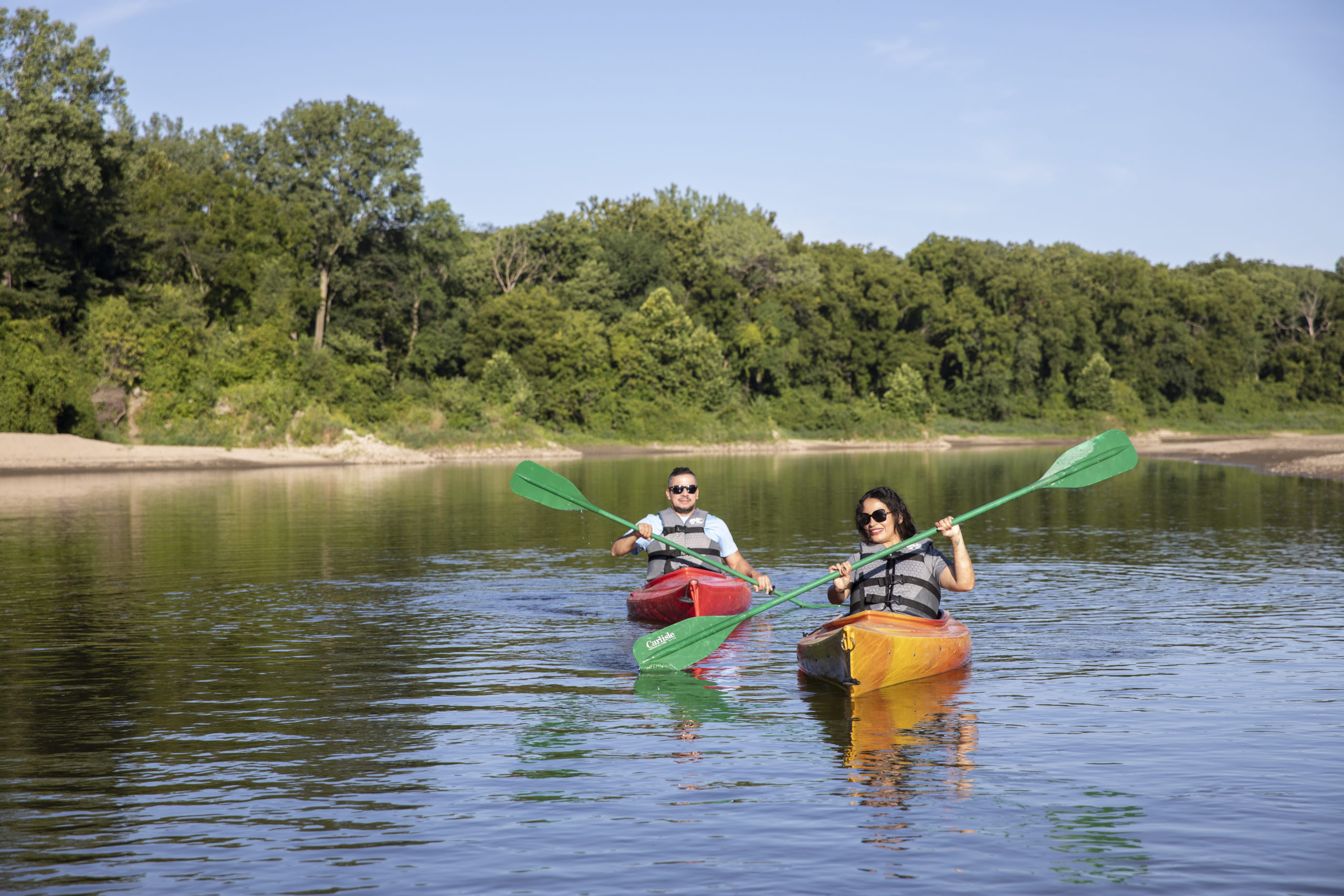 Two people kayaking down a river