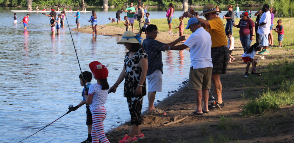 A Hispanic family fishing along the water's edge