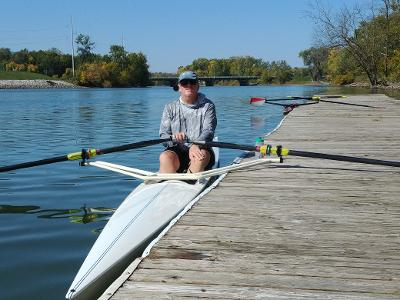 A man sitting in a rowing boat next to the dock