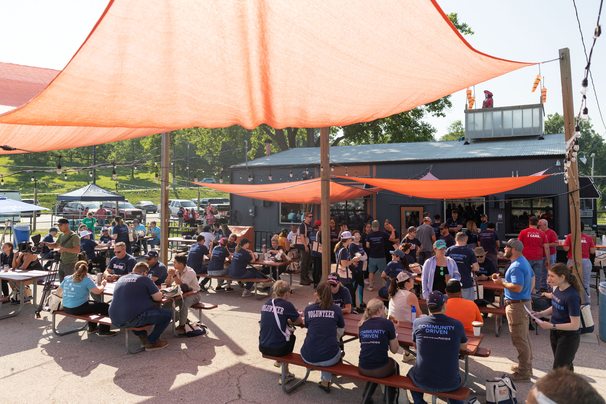 A group gathered under sun shades outdoors