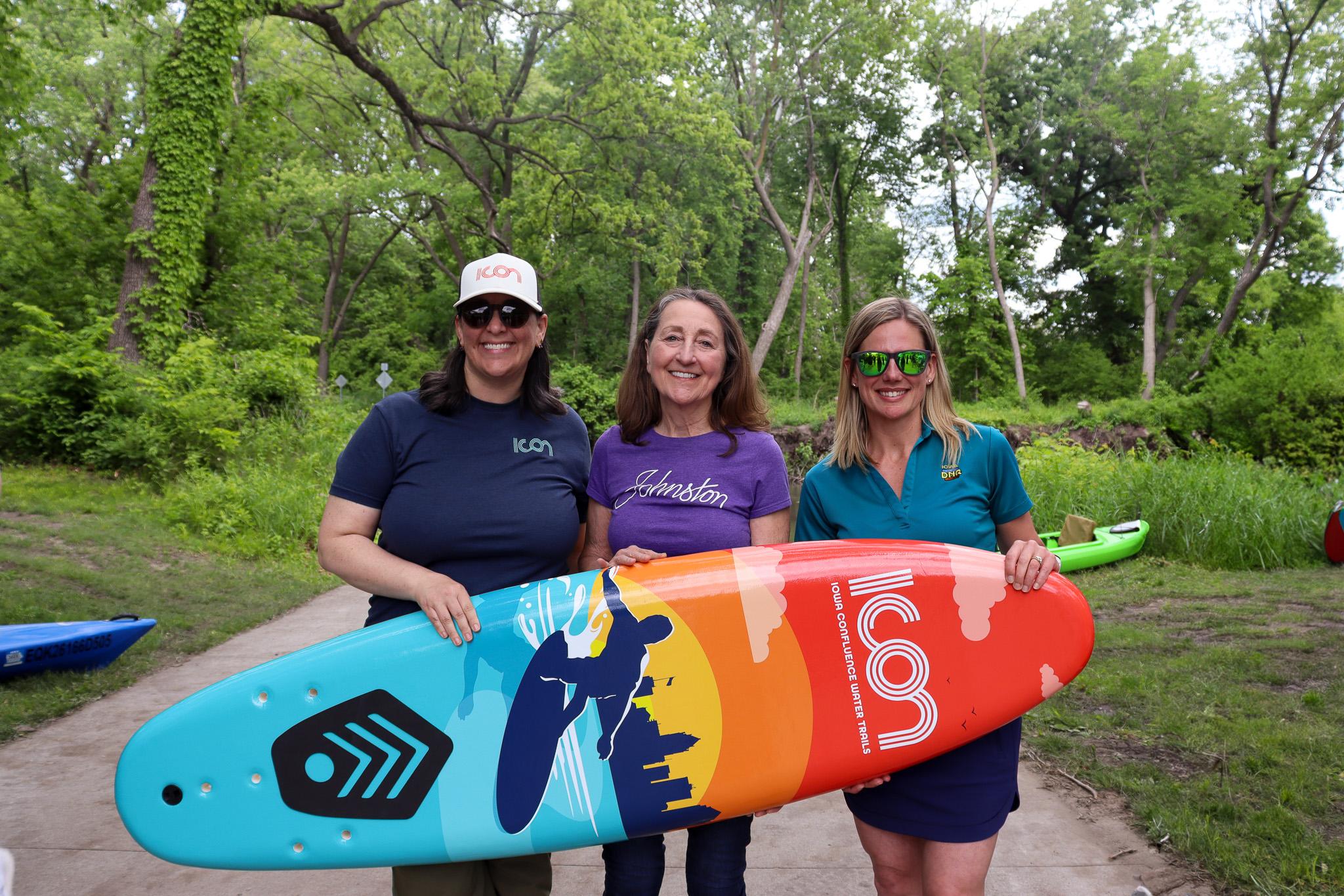 Group of three women holding the ICON surfboard