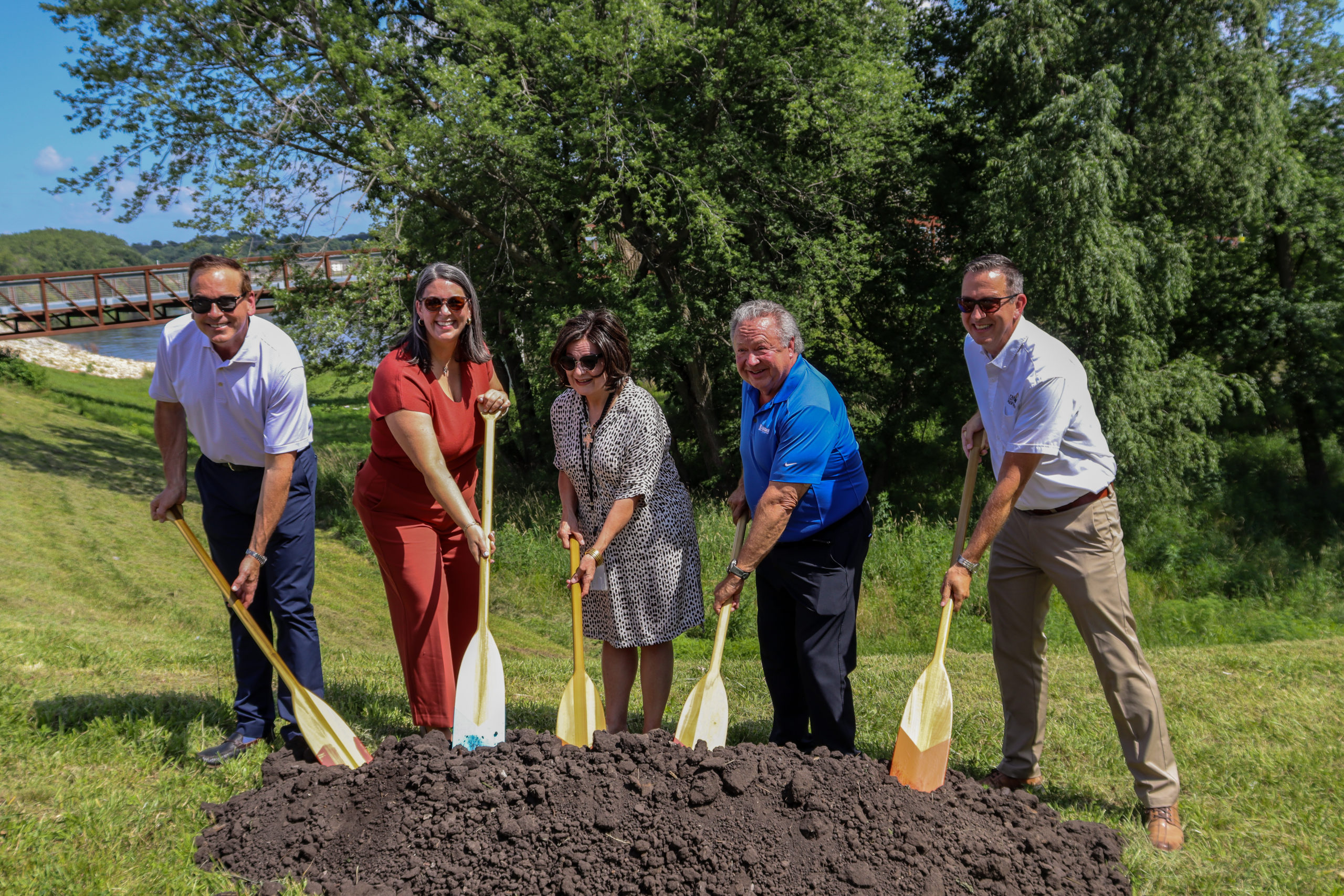 A group digging with oars in a pile of dirt